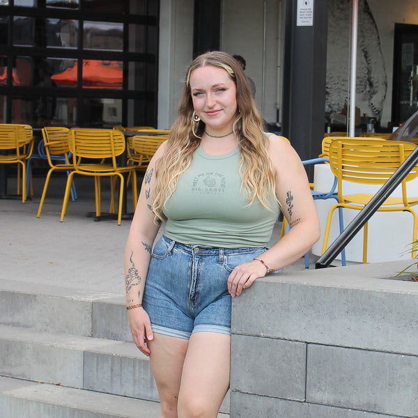 Girl wearing green top and jean shorts