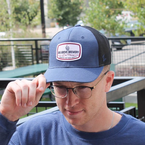 Man with glasses wearing blue Big Grove hat