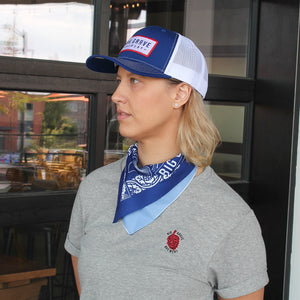 Woman with blue bandana in blue and white Big Grove hat