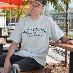 Man in Big Grove 90s Dad Tee sitting on table