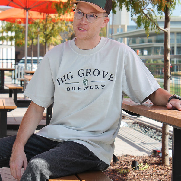 Man in Big Grove 90s Dad Tee sitting on table