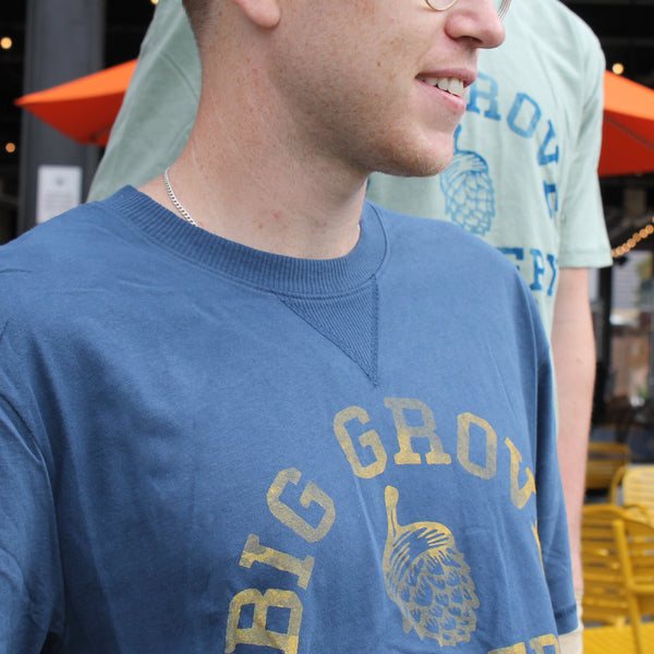 Man with blue Big Grove t-shirt with yellow text