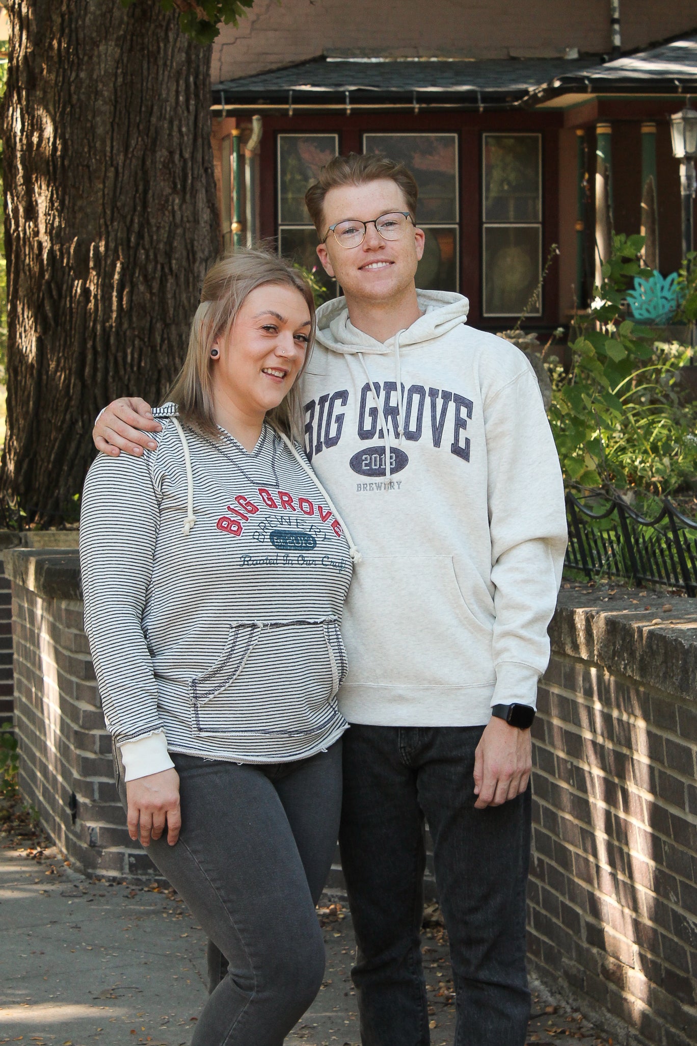 Man and woman wearing Big Grove sweatshirts