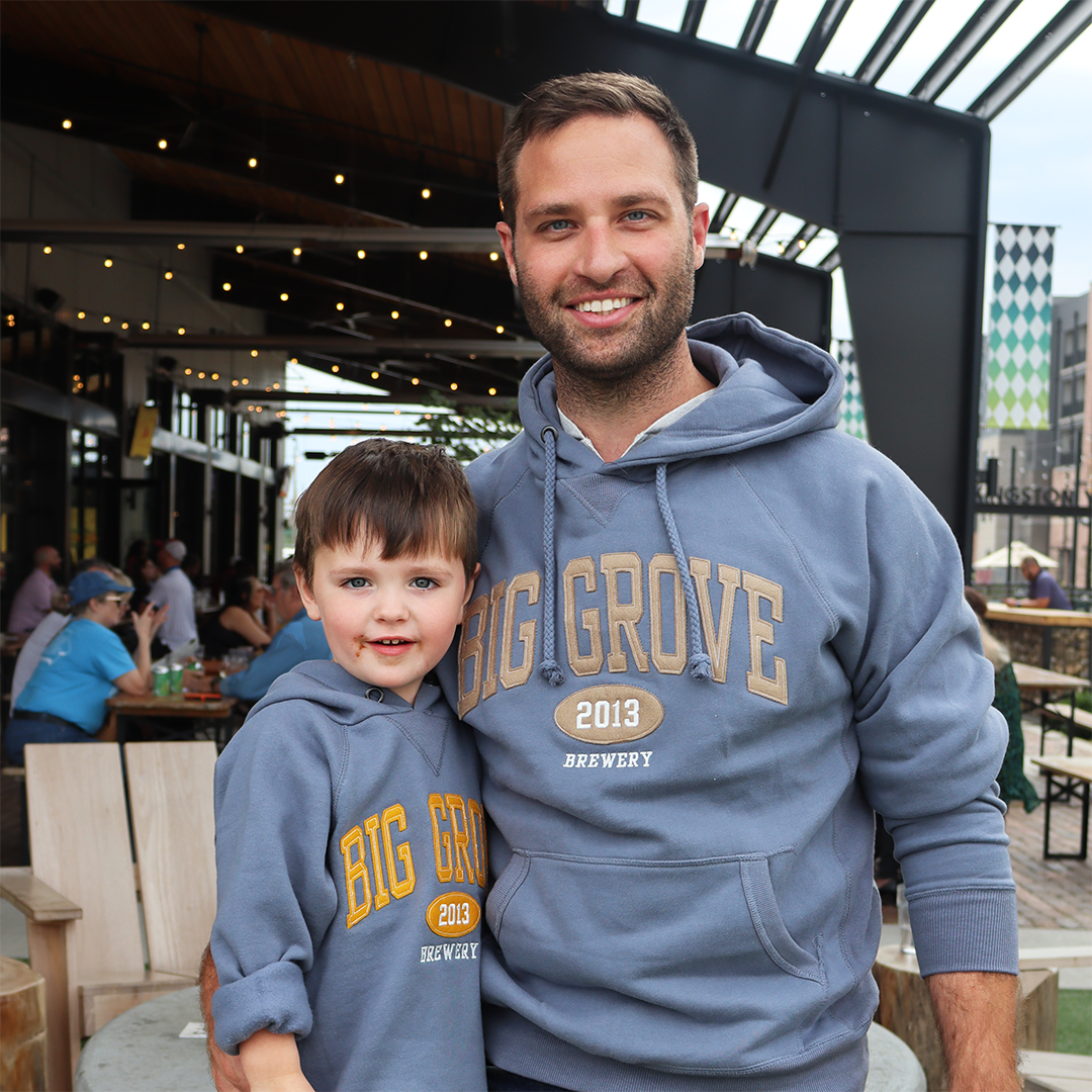 Boy and man wearing blue-gray Big Grove sweatshirt