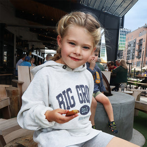 Girl with gray Big Grove sweatshirt eating a cookie